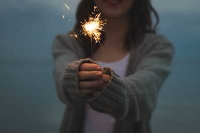 Woman holding sparkler at dusk. The coping tools in CBT therapy will help you overcome anxiety and OCD.