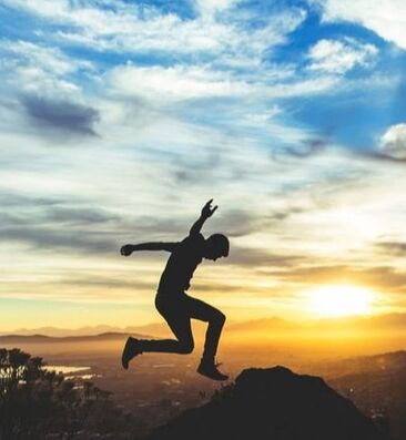 Man jumping over mountains. CBT can help you manage anxiety and OCD.